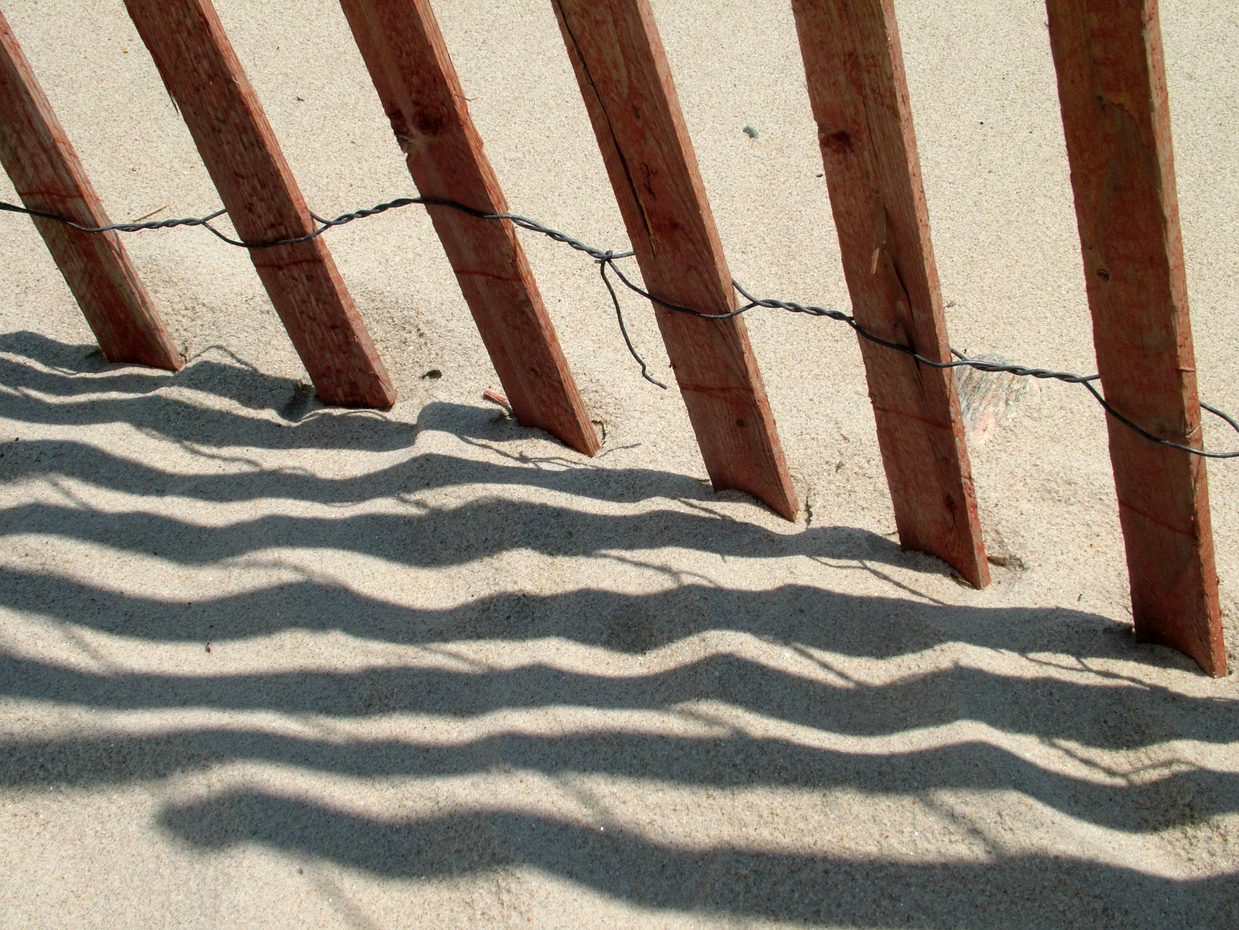 Photo of picket fence on a sandy beach