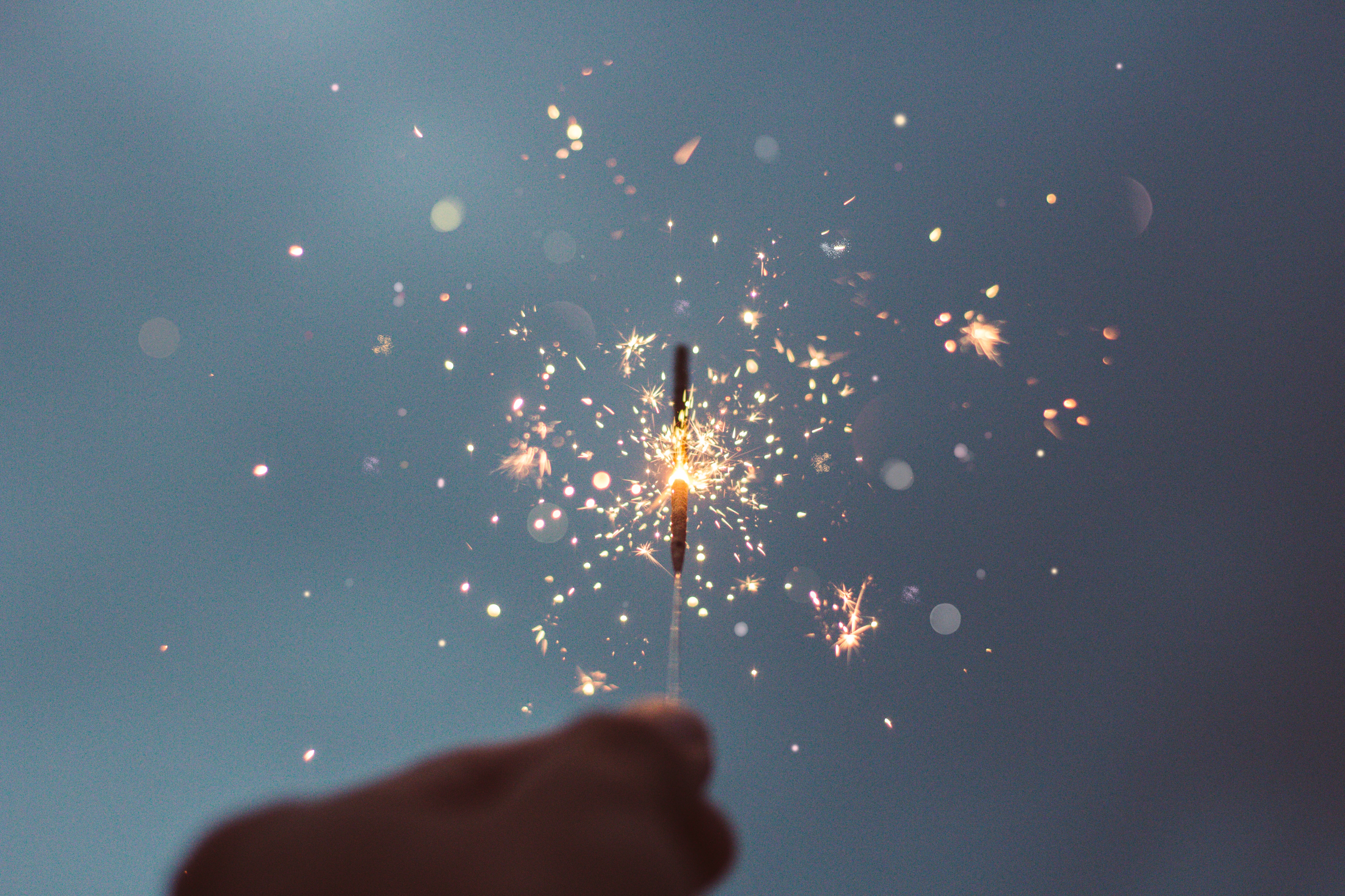 a person holding a lit sparkler