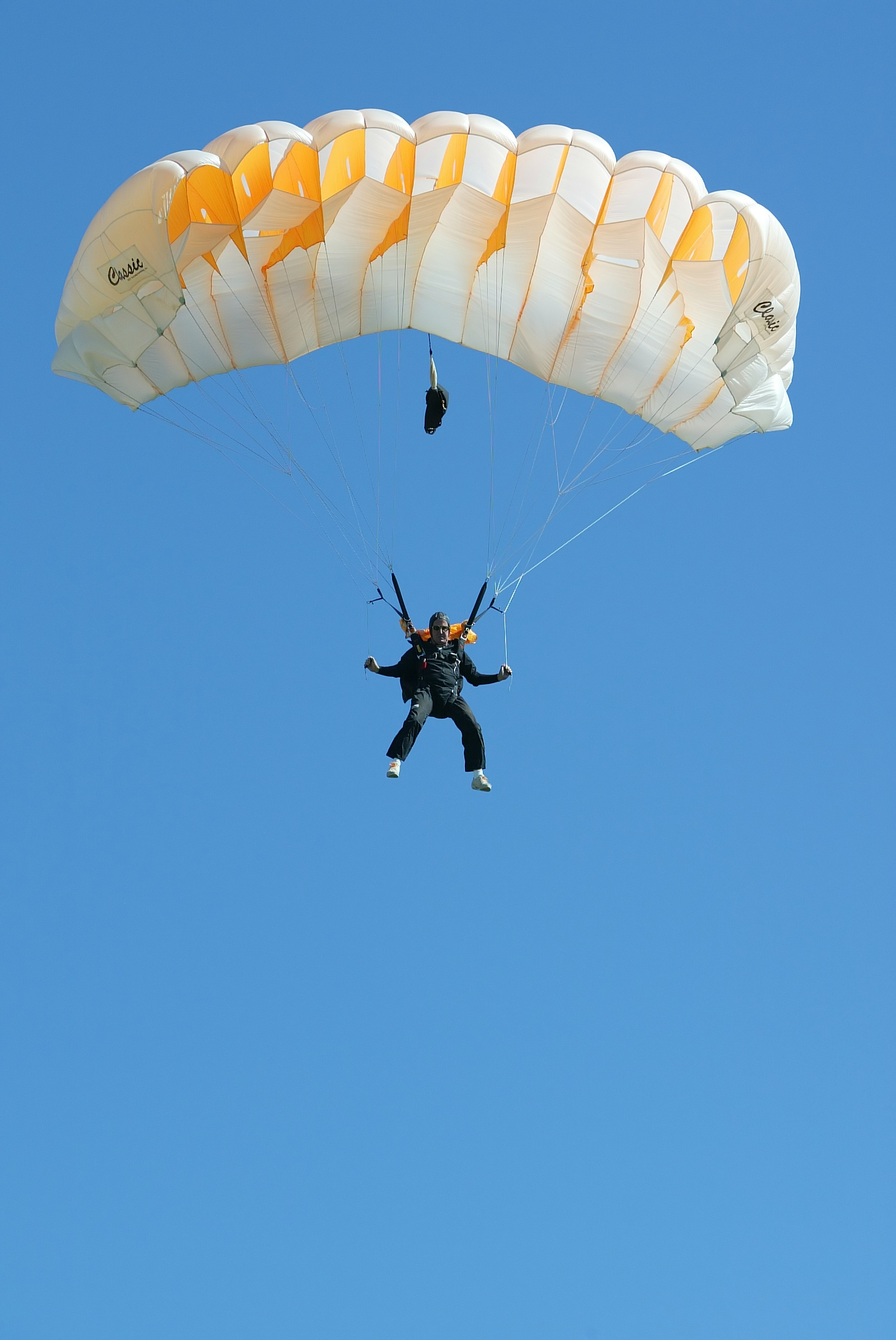 View from below of a person using a parachute