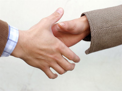 A picture of a man's hand and woman's hand involved in a handshake.