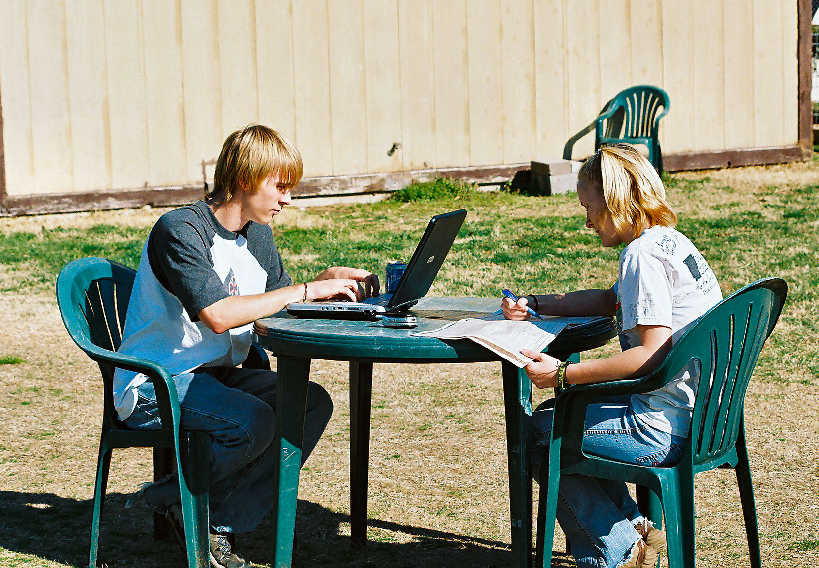 photo of two students, one is on the computer and the other is helping him