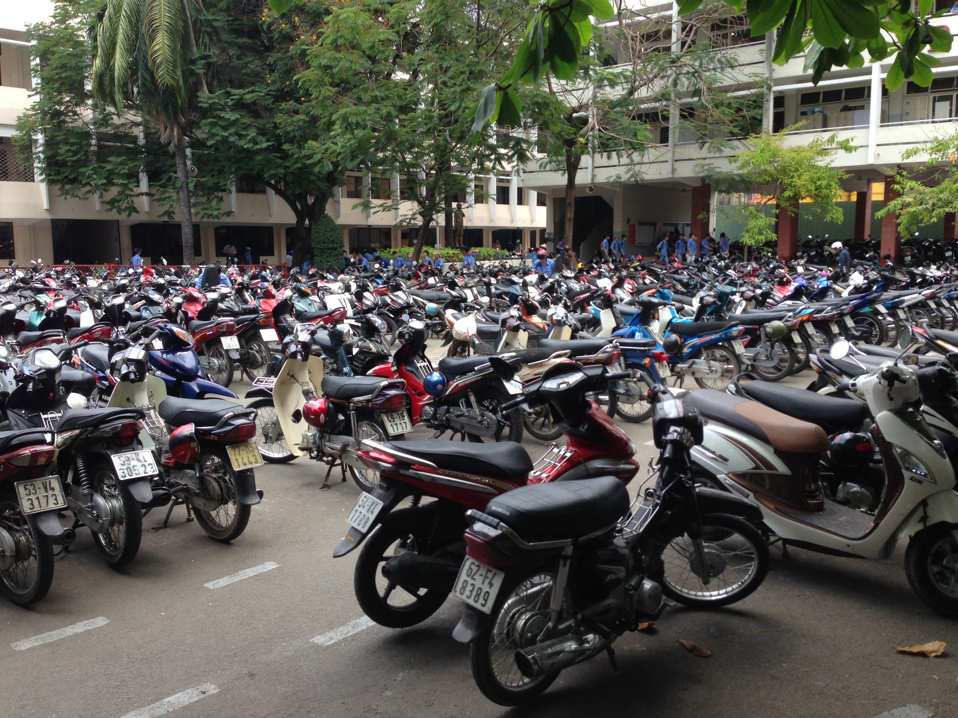 Photo of numerous motorcycles parked at a technical college in Vietnam.