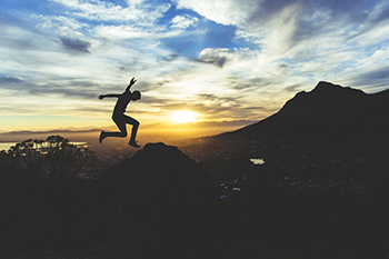 jumping in the mountains at sunset