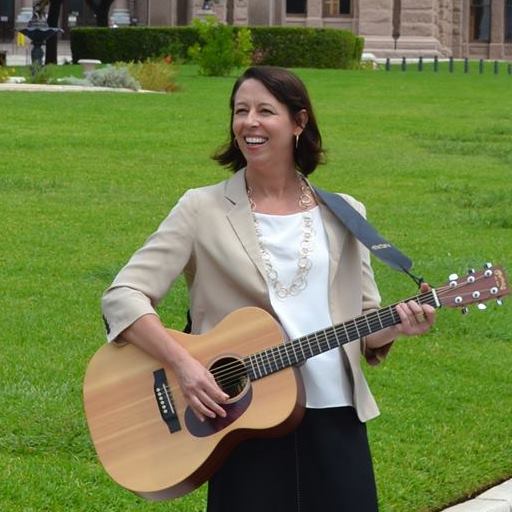 Judith Sebesta playing a guitar.