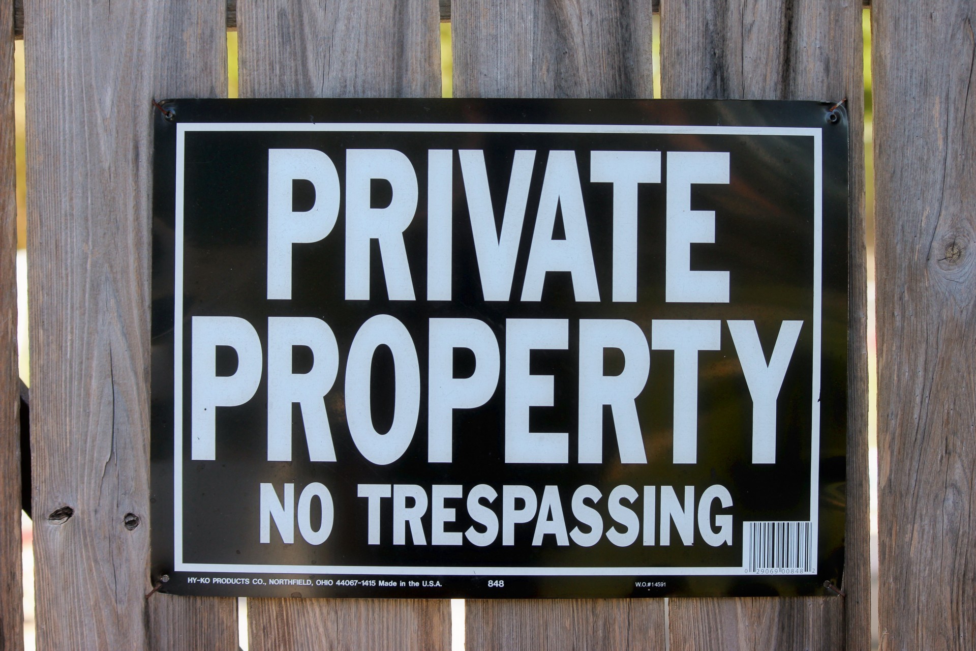 A sign on a fence that states to keep out its private property.