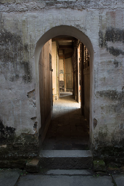 view thorugh a courtyard, gray stone doorway, down into a hallway. 