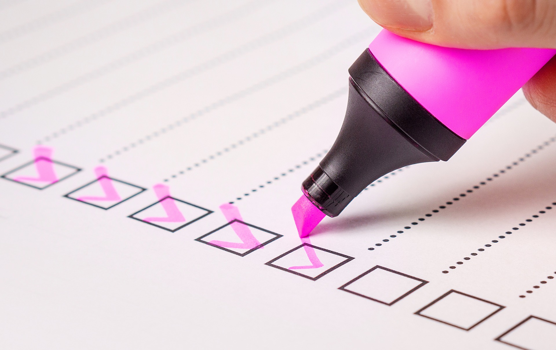 A list of checkboxes being checked with a pink highlighter pen