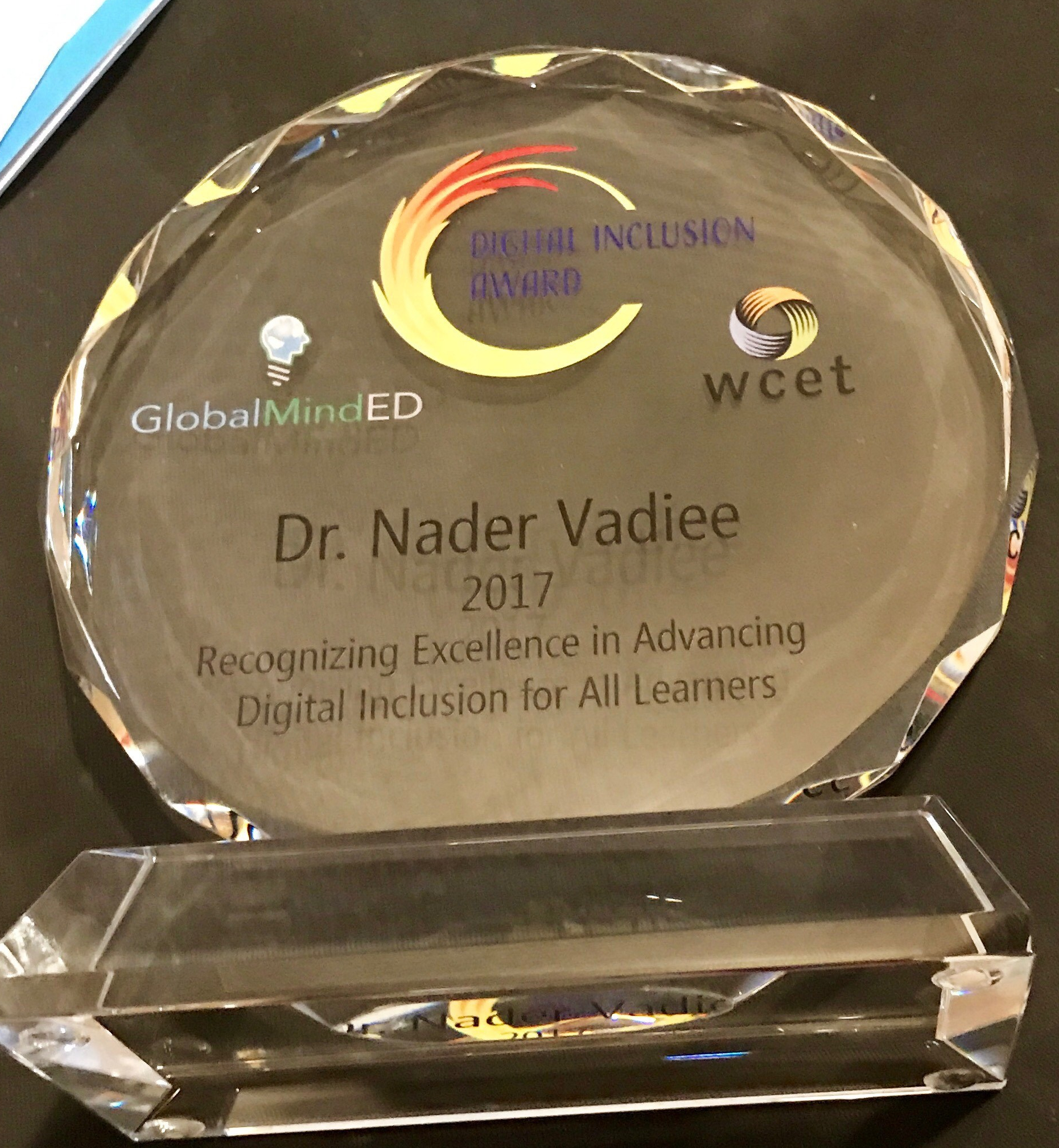 Glass plaque for the 2017 award winner Dr. Nader Vadiee. Plaque reads "recognizing excellence in advancing digital inclusion for all learners."
