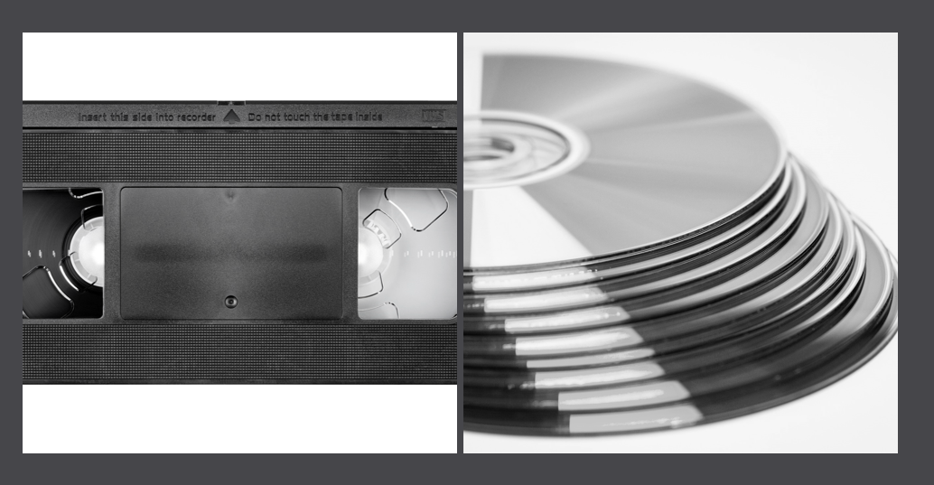 a black and white photo of a vhs tape and cds/dvds
