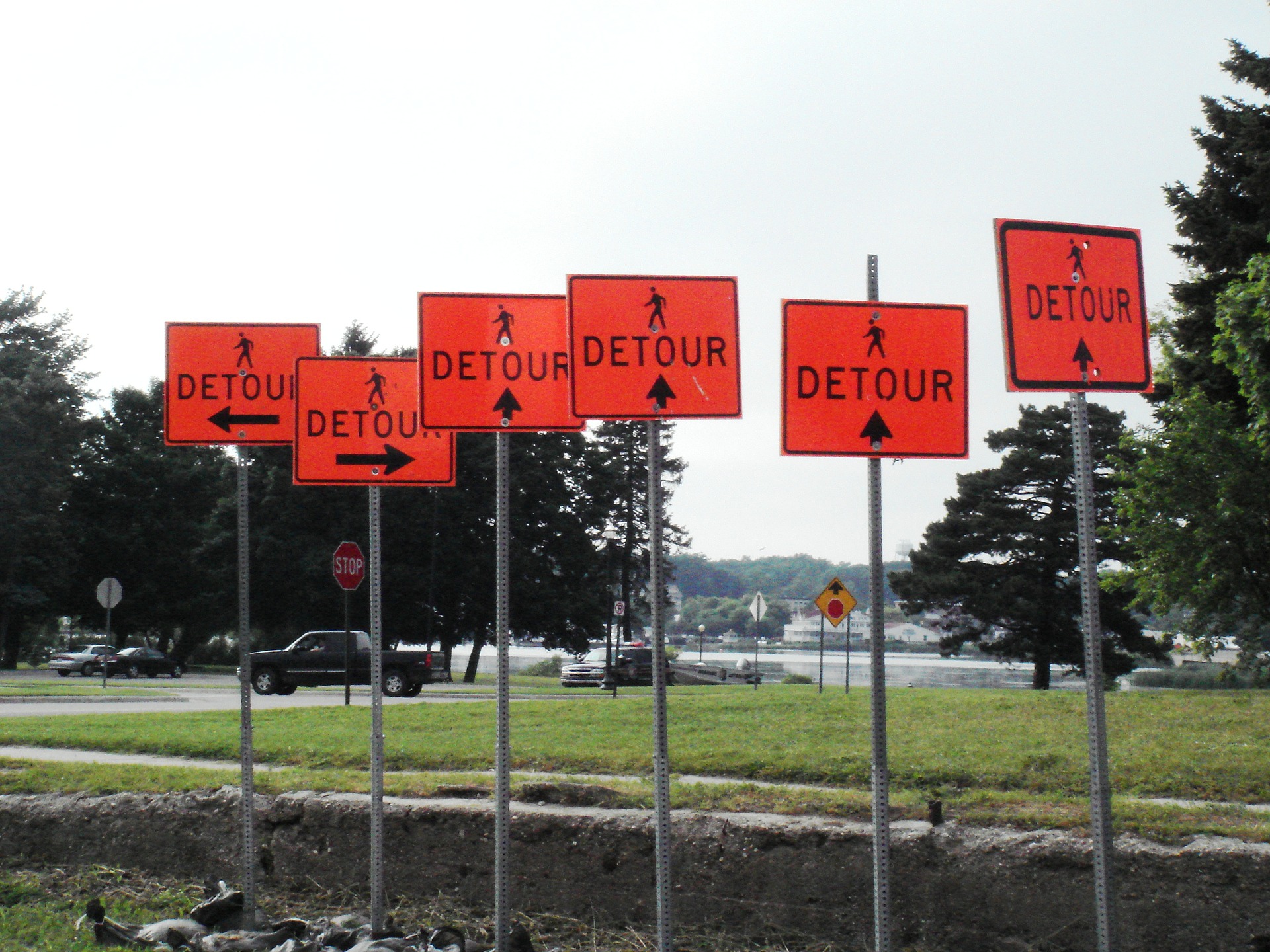 Several detour signs with different arrows facing different directions.