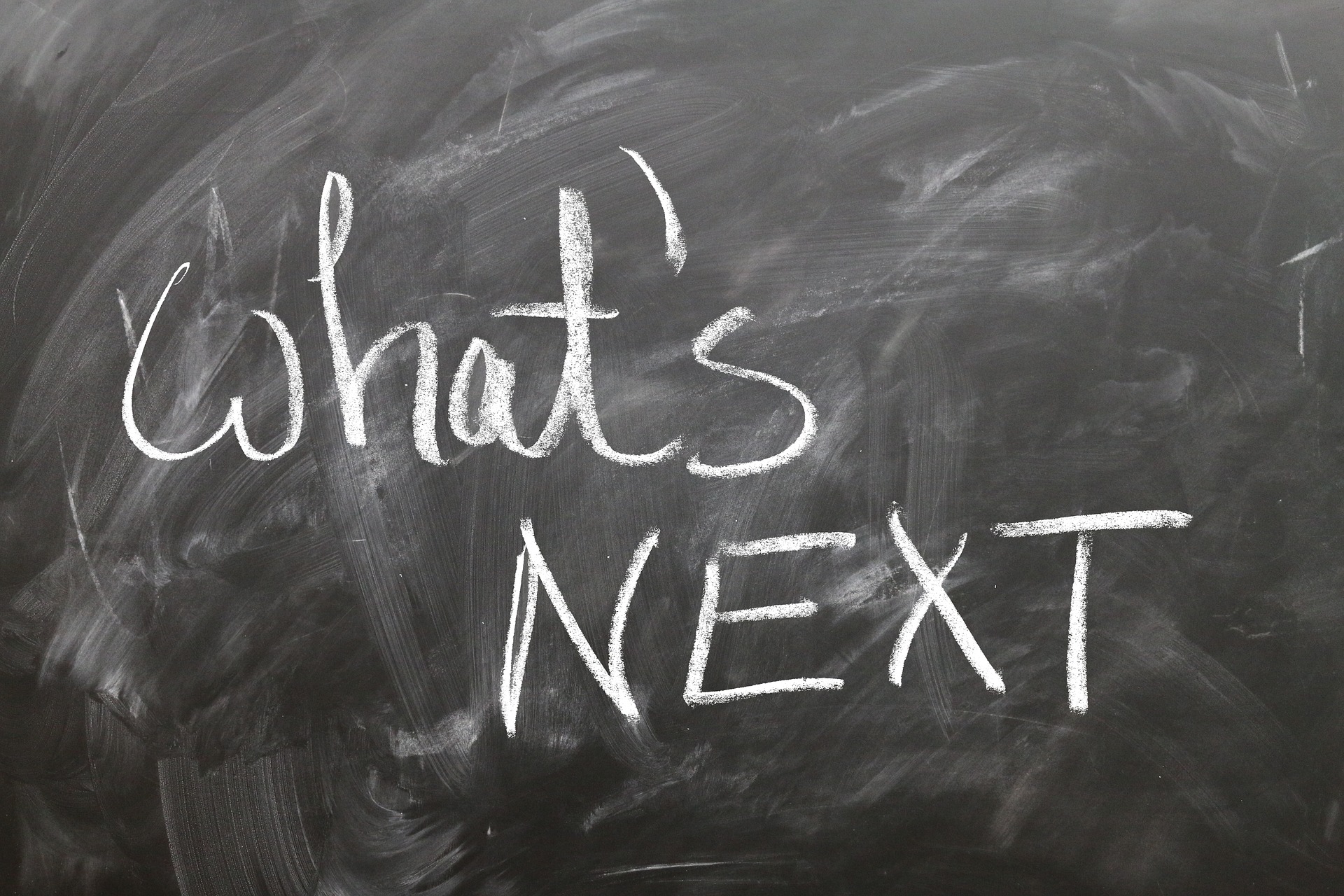 A chalkboard that reads "what's next" in chalk