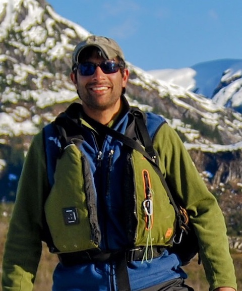 Nathaan author photo. Author stands in front of a snowy mountain in climbing gear.