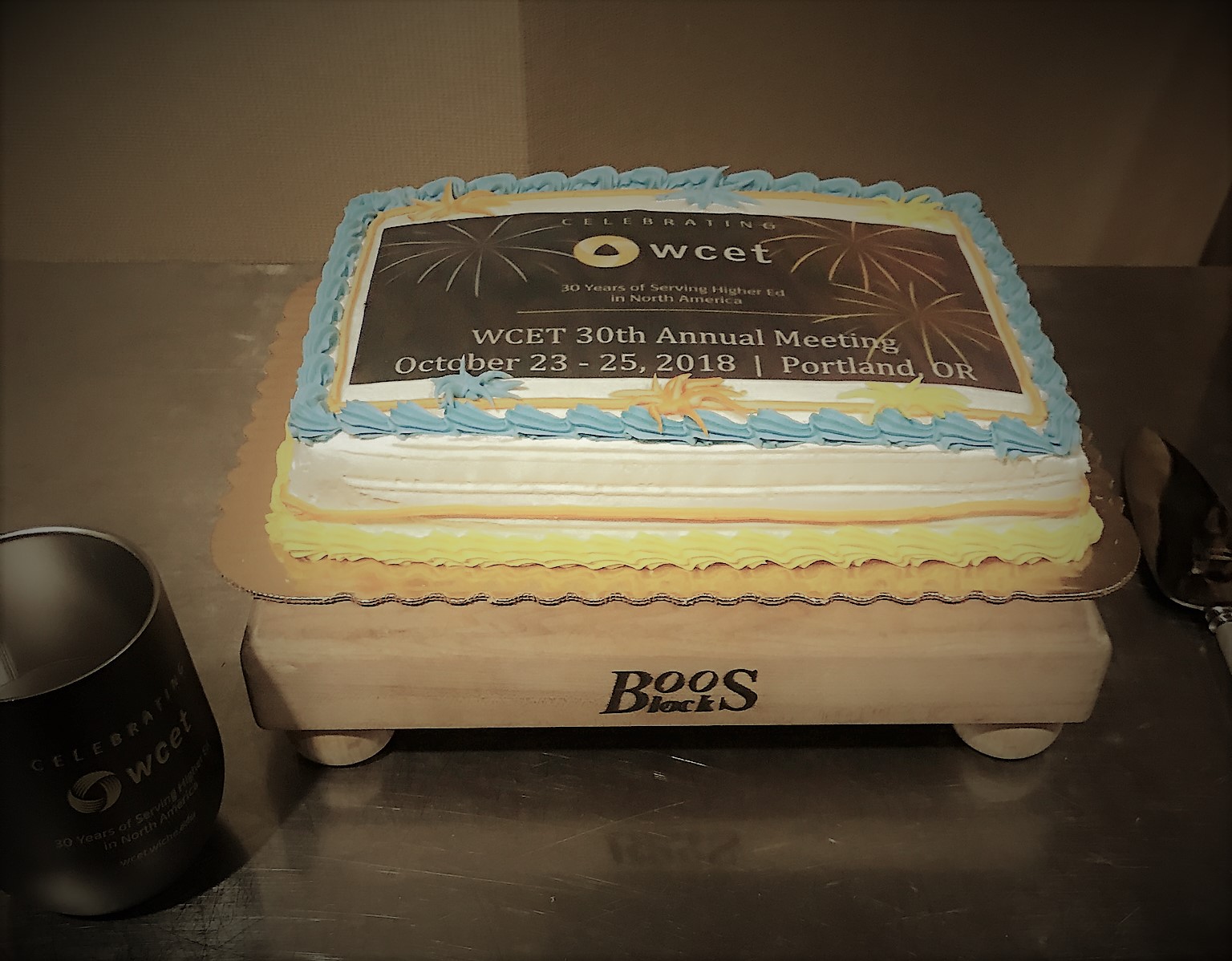 A small cake with the annual meeting logo printed on top which reads "celebrating wcetL 30 years of serving higher ed in north america. WCET annual meeting. October 23-25, 2018, Portland, OR"