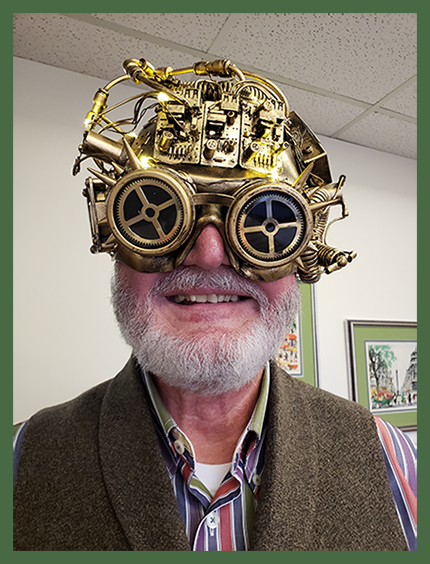 Mike wearing bronze and gold steampunk glasses with gears, wires, and gold lenses.
