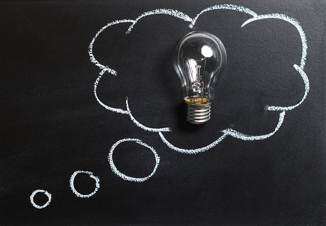Picture of a single light bulb placed against a blackboard. The light bulb is surrounded by a white cloud drawn in chalk.