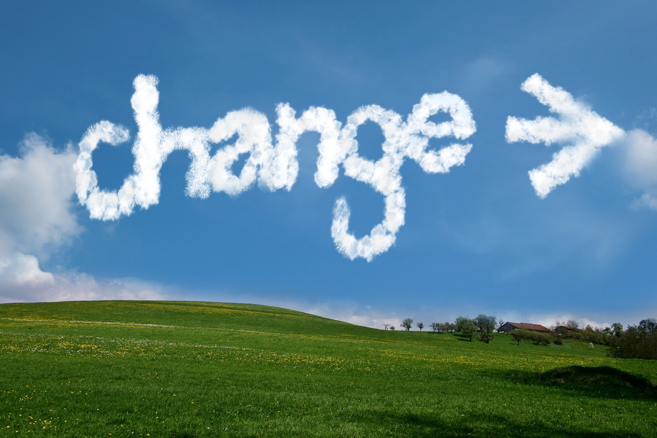 Change written in the sky in while letters over green grass