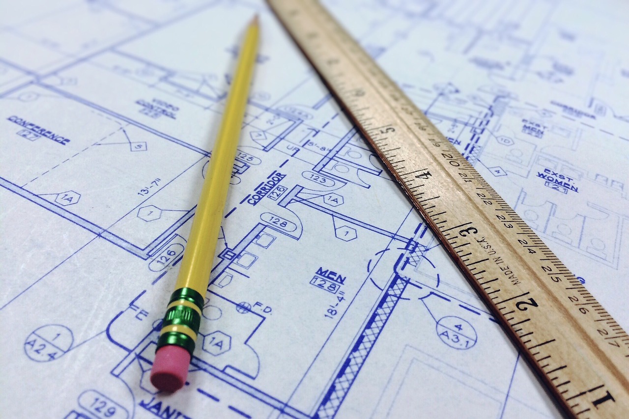 photo of a blueprint, ruler, and pencil