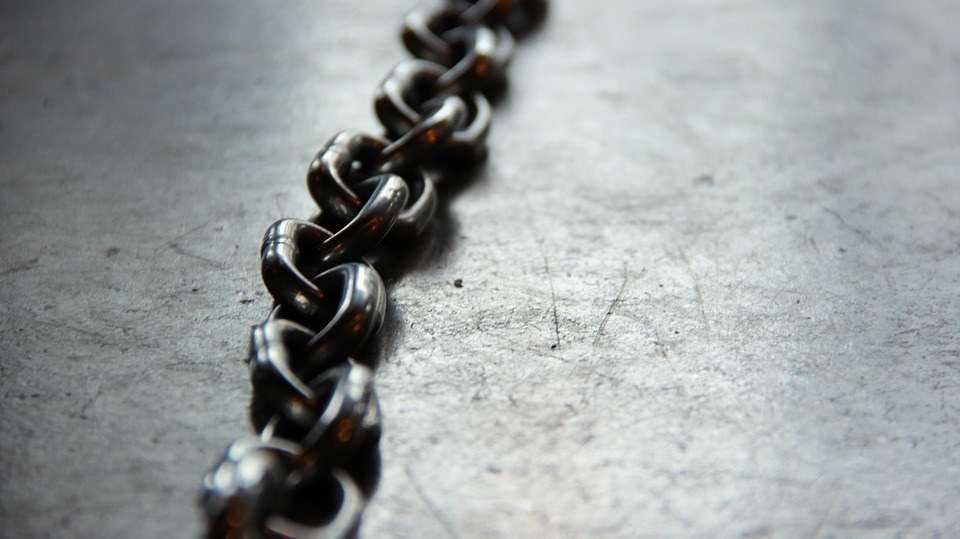 a dark metal chain on a concrete floor