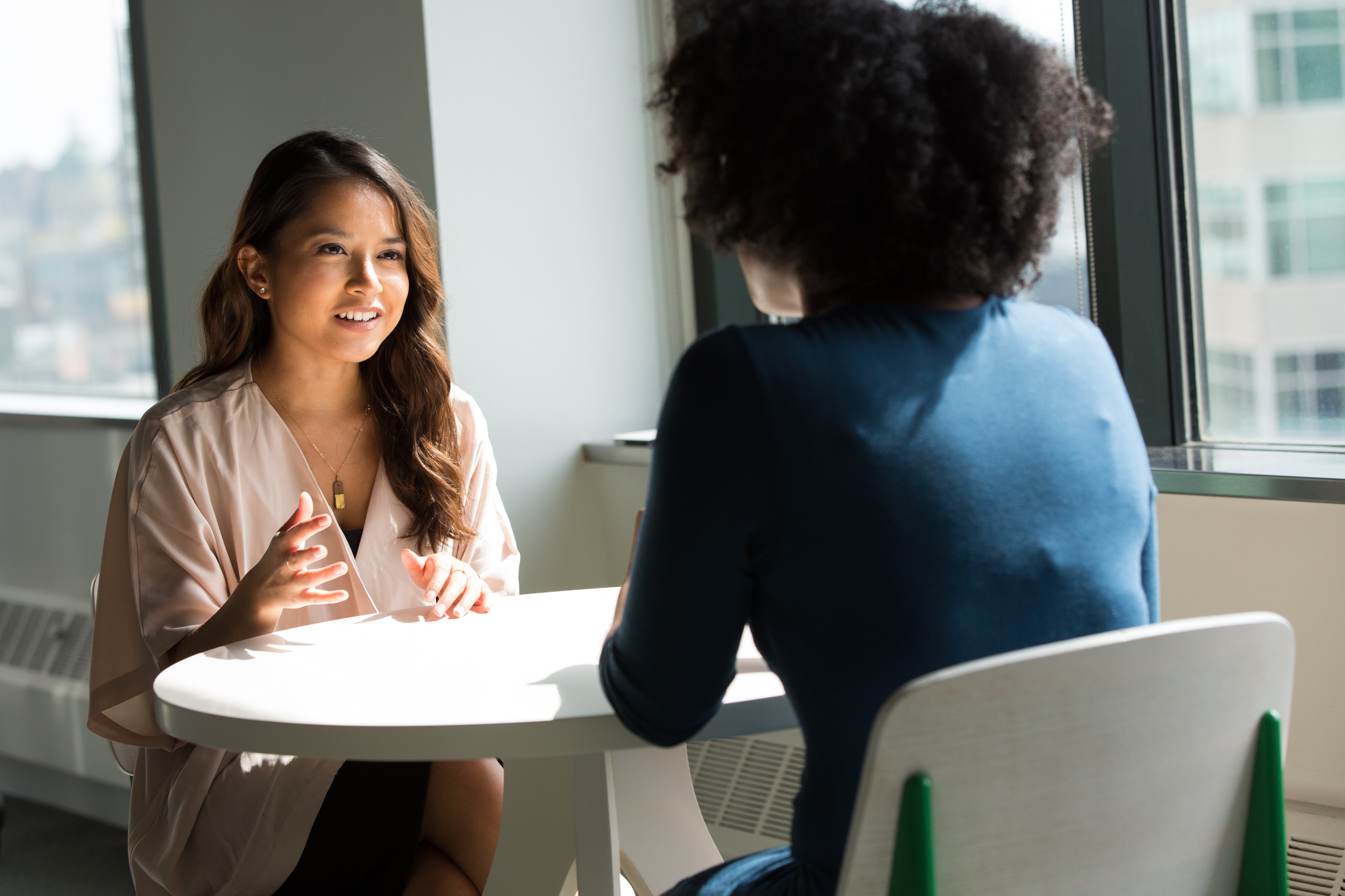 two women talking at a table