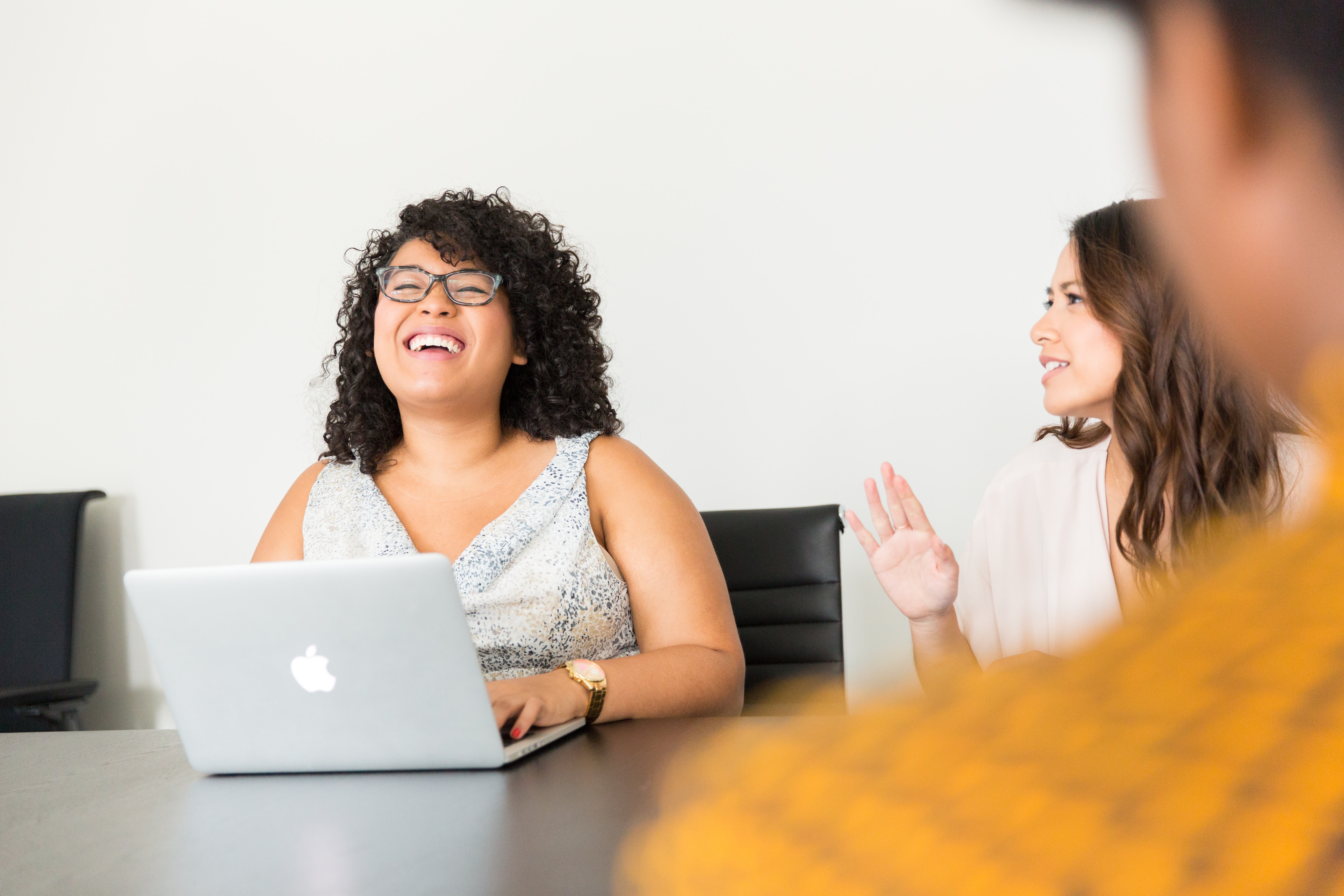 Professional women at a table laughing