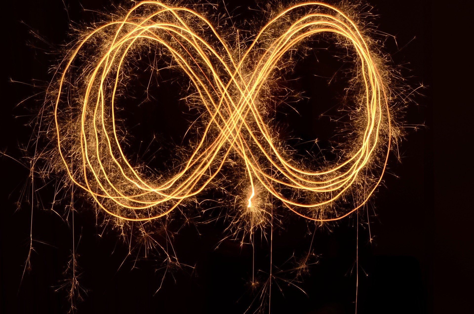 an infinity sympol drawn using sparklers/light