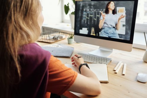 woman listening to someone present on a computer screen