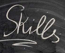 The word "skills" written on a black chalkboard in white chalk.