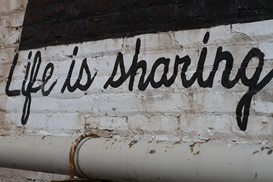 "life is sharing" written on a wall 