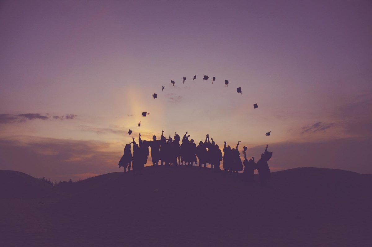 Group of graduates throwing their hats in the air.