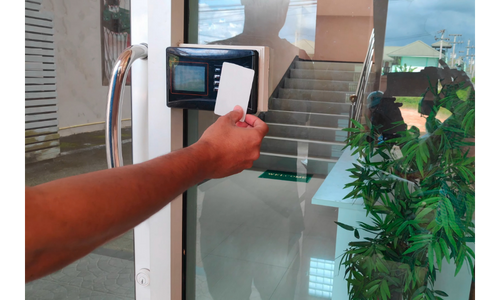 Photo of a person using a keycard to gain entry into a secure building.