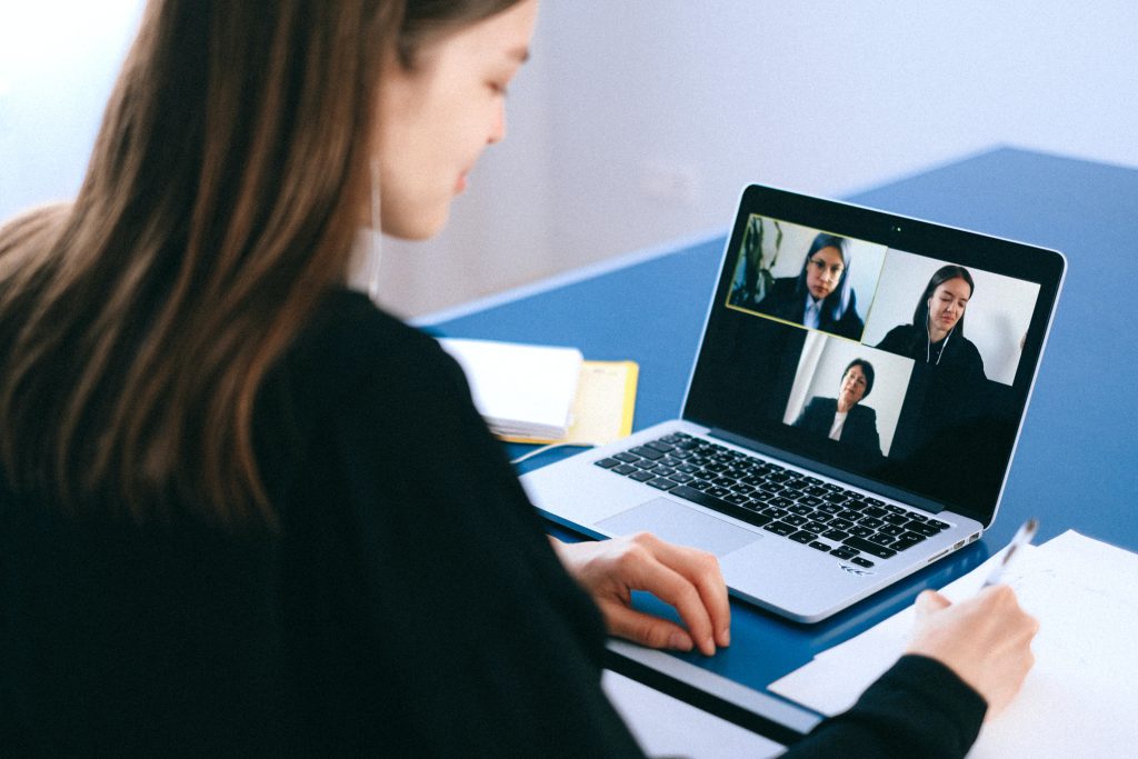  A woman participating with a video conference on a laptop.