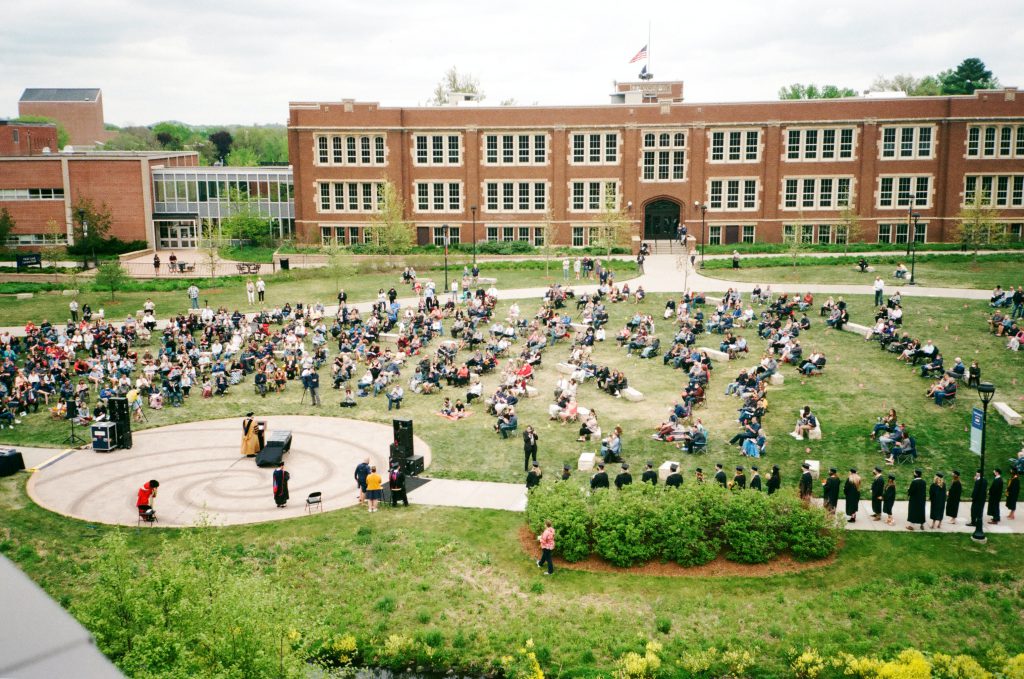 Several groups of students on a college campus, attending a graduation.