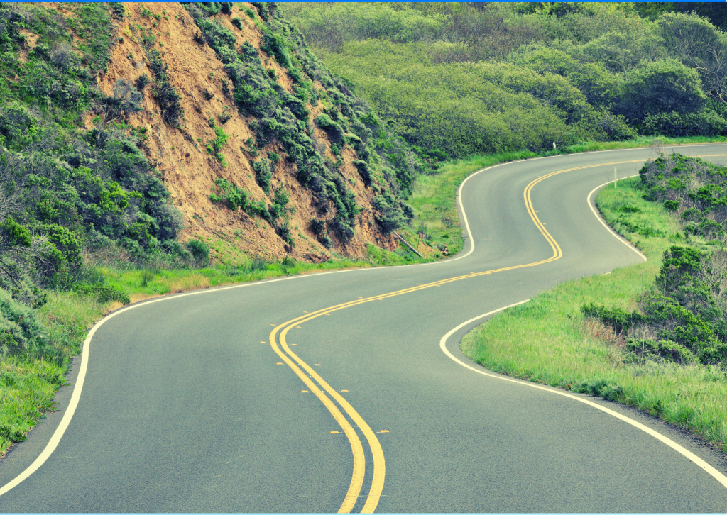 A long, winding road leading around a mountain
