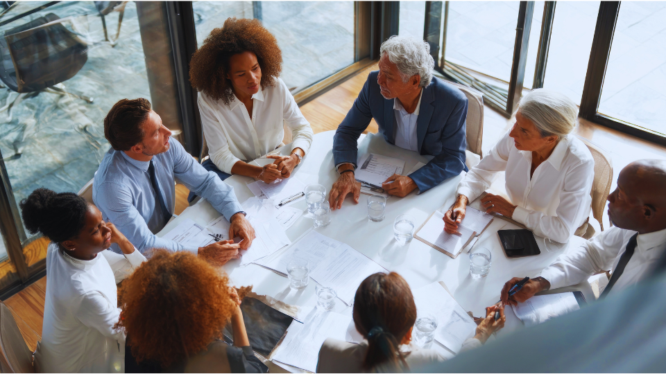 group of professional individuals around a table talking