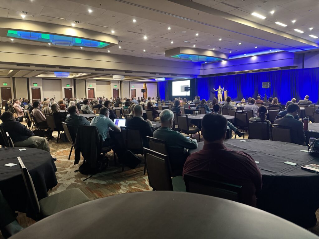 Wide shot of hundreds of WCET conference attendees watching the 2025 keynote speaker