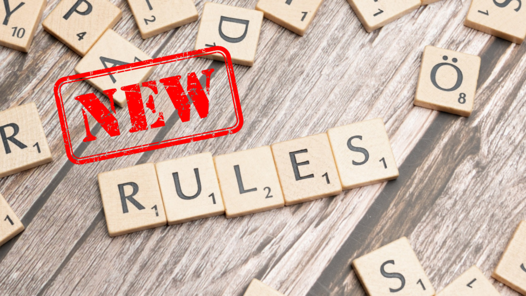 scrabble tiles spelling out RULES and a NEW stamp